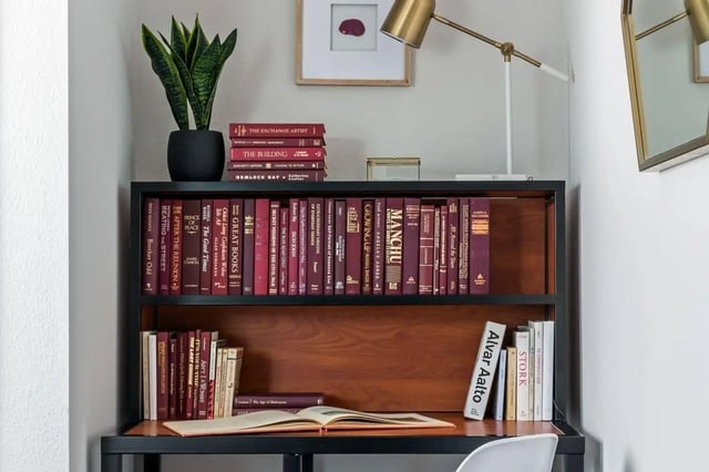 Bookshelf with plant lamp and open book study area at The Kristi in Corpus Christi Student Accommodation
