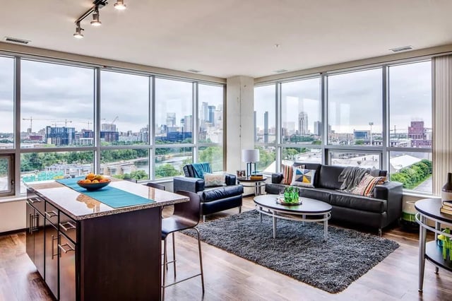 Kitchen island sofa chairs coffee table rug living room at The Bridges Dinkytown in Minneapolis Student Accommodation