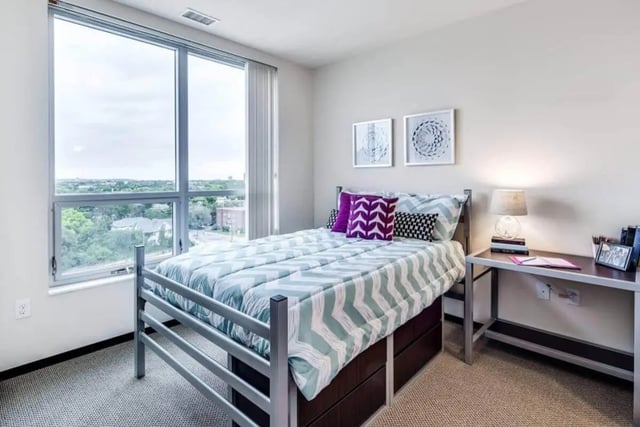 Bed with patterned duvet and desk with lamp bedroom at The Bridges Dinkytown in Minneapolis Student Accommodation