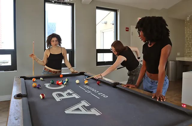 Three women playing billiards game room at Arc at Old Colony in Chicago Student Accommodation