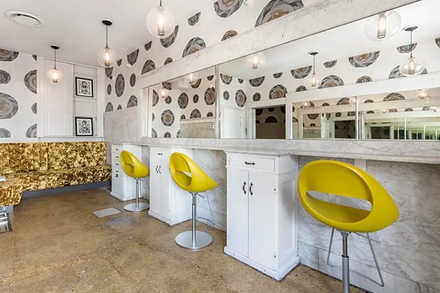 Gold sofa yellow chairs white cabinets living room at Arc at Old Colony in Chicago Student Accommodation