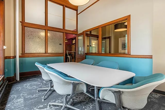 White table teal chairs patterned carpet communal area at Arc at Old Colony in Chicago Student Accommodation