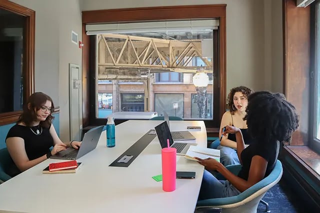 Students working on laptops at a large table study area at Arc at Old Colony in Chicago Student Accommodation