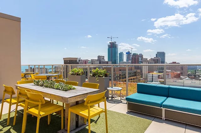Rooftop patio with table chairs and sofa exterior at Arc at Old Colony in Chicago Student Accommodation