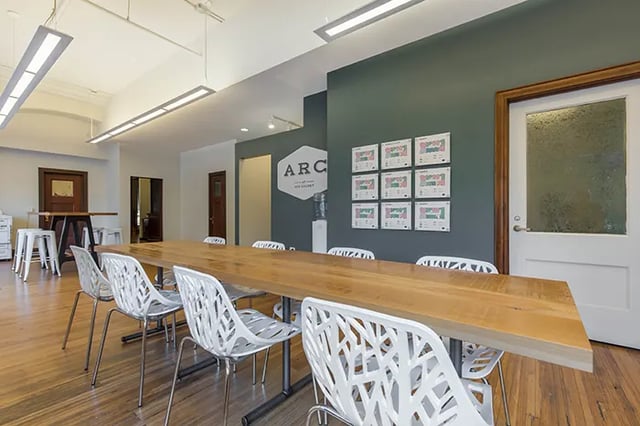 Long wooden table with white chairs communal area at Arc at Old Colony in Chicago Student Accommodation