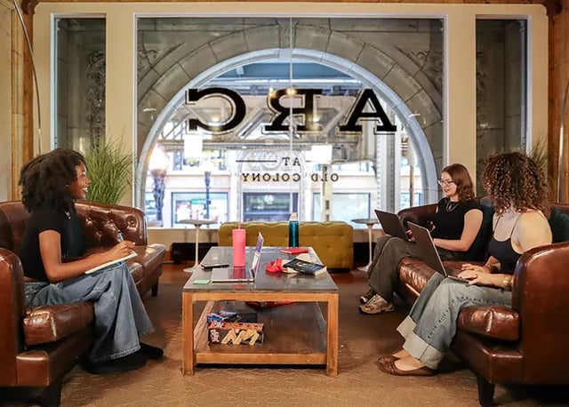 Students relax on sofas with laptops living room at Arc at Old Colony in Chicago Student Accommodation
