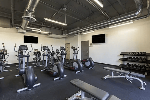 Ellipticals treadmills weights and benches gym area at ICON in Goleta Student Accommodation