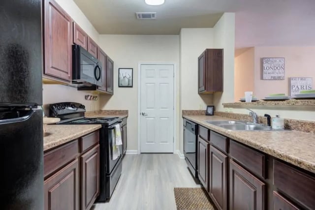 Dark cabinets microwave oven sink and dishwasher kitchen at High View in San Antonio Student Accommodation