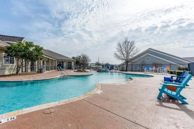 Blue chairs pool with seating and tables exterior at High View in San Antonio Student Accommodation