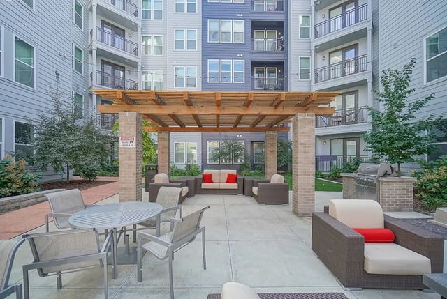 Outdoor seating area with pergola and grill patio area at Academy in Lincoln Student Accommodation