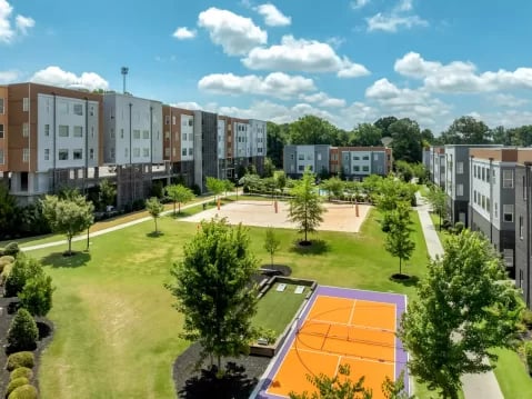 Apartments with volleyball court and tennis court exterior at GrandMarc Clemson in Clemson Student Accommodation