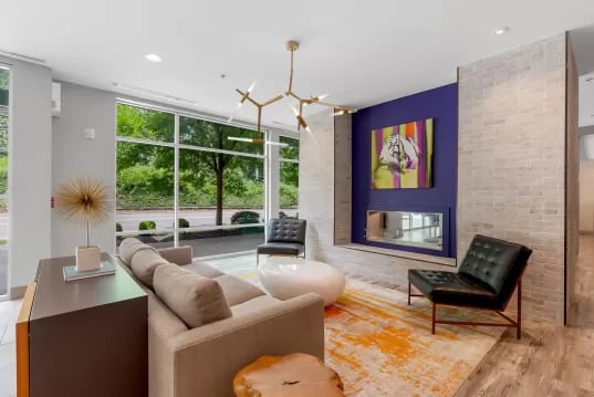 Modern lounge with sofas fireplace artwork chandelier living room at GrandMarc Clemson in Clemson Student Accommodation