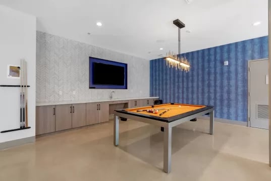 Pool table billiard cues mounted on wall game room at GrandMarc Clemson in Clemson Student Accommodation