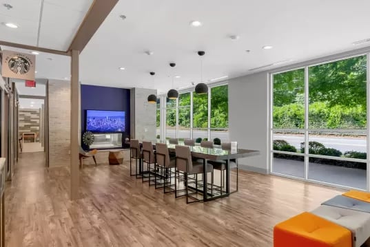 Large table with stools TV on wall Living area at GrandMarc Clemson in Clemson Student Accommodation