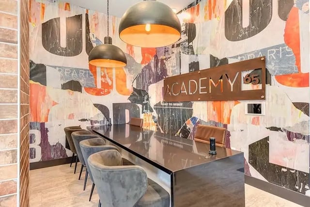 Long table plush chairs abstract wallpaper study area at Academy65 in Sacramento Student Accommodation