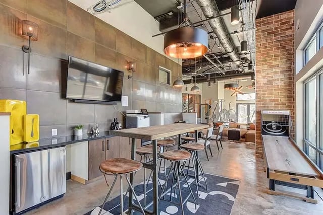 TV mini fridge bar stools table game area living room at Academy65 in Sacramento Student Accommodation