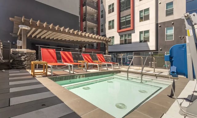Four red lounge chairs hot tub exterior at Academy65 in Sacramento Student Accommodation
