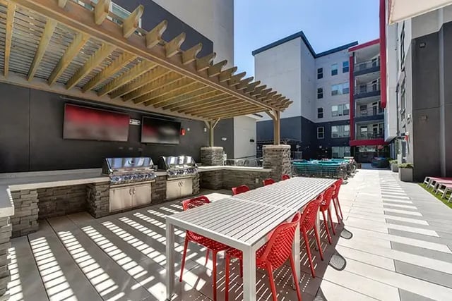 Outdoor kitchen with grills and dining table patio at Academy65 in Sacramento Student Accommodation