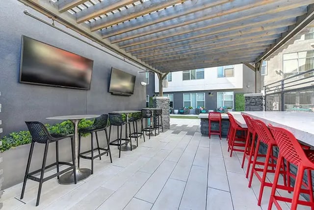 Outdoor seating with TVs bar and chairs patio at Academy65 in Sacramento Student Accommodation
