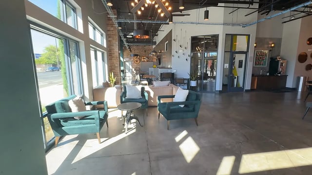 Green chairs sectional sofa round table common area at Academy65 in Sacramento Student Accommodation