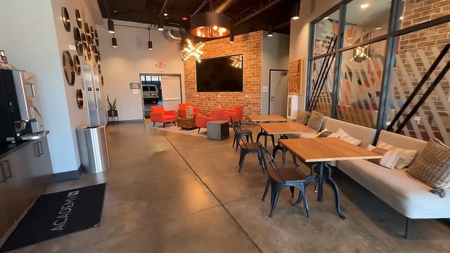 Lounge area with orange chairs and tables Living room at Academy65 in Sacramento Student Accommodation