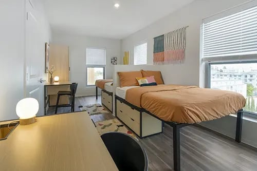 Two beds desks chairs and lamps bedroom at IDENTITY Logan Park in Berkeley Student Accommodation