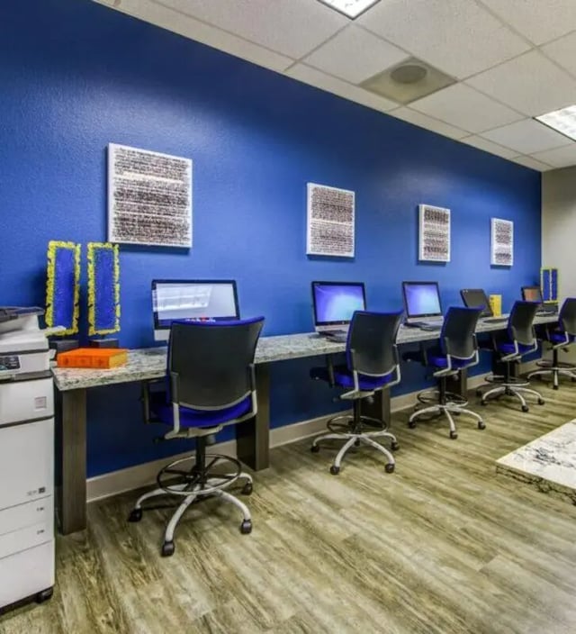 Computers chairs printers and artwork study area at GrandMarc at University Village in Riverside Student Accommodation