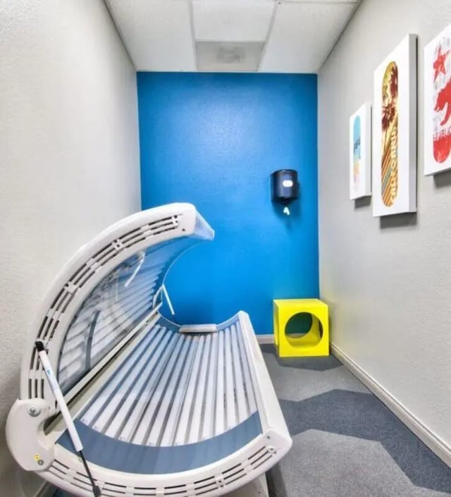 Tanning bed on carpet with artwork and yellow cube room. at GrandMarc at University Village in Riverside Student Accommodation