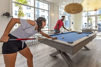 Students playing pool at a recreation area living room at Uncommon Wilmington in Wilmington Student Accommodation