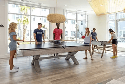 Students playing ping pong and foosball recreation area at Uncommon Wilmington in Wilmington Student Accommodation