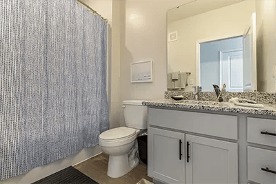 Toilet vanity with shower curtain and mirror bathroom at Uncommon Wilmington in Wilmington Student Accommodation