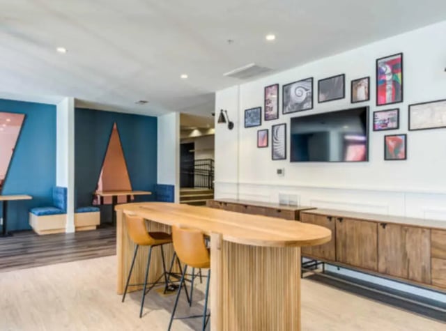 Modern communal space with large table television and seating area at Grandmarc at The Corner in Charlottesville Student Accommodation