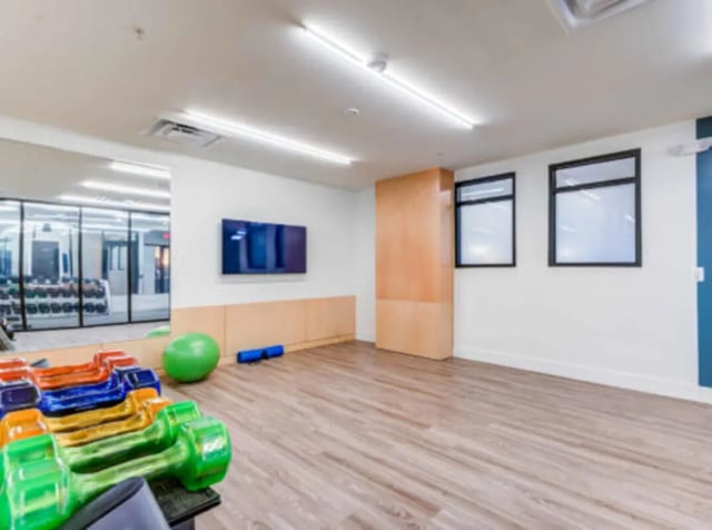 Dumbbells exercise ball and TV fitness room at Grandmarc at The Corner in Charlottesville Student Accommodation