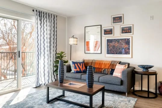 Sofa coffee table artwork and balcony living room at Grandmarc at The Corner in Charlottesville Student Accommodation