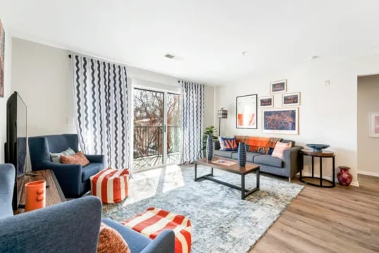 Gray sofa with patterned pillows and colorful throws living room at Grandmarc at The Corner in Charlottesville Student Accommodation