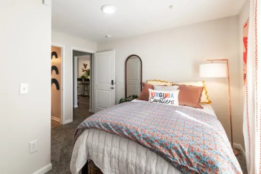 Bed pillows mirror floor lamp bedroom at Grandmarc at The Corner in Charlottesville Student Accommodation