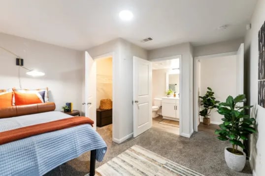 Bed, closet, bathroom, plants bedroom at Grandmarc at The Corner in Charlottesville Student Accommodation