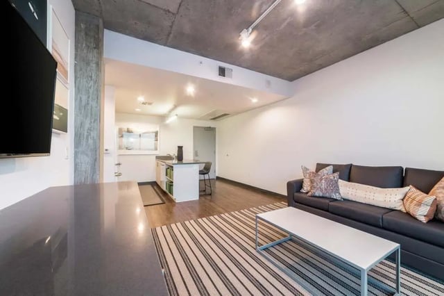 Dark couch island kitchen and striped rug living area at Malibu Tucson Apartments in Tucson Student Accommodation