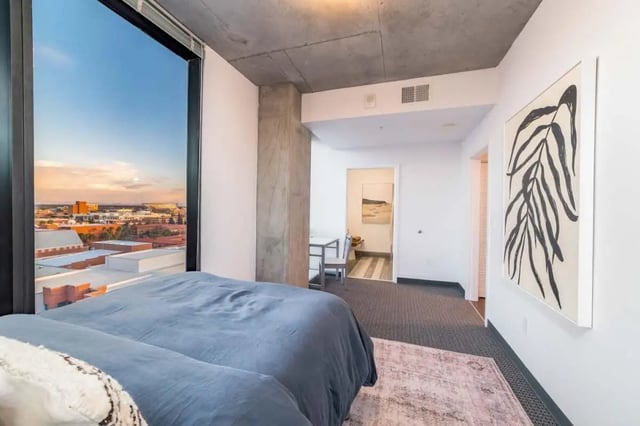 Bed with large window view and artwork bedroom at Malibu Tucson Apartments in Tucson Student Accommodation