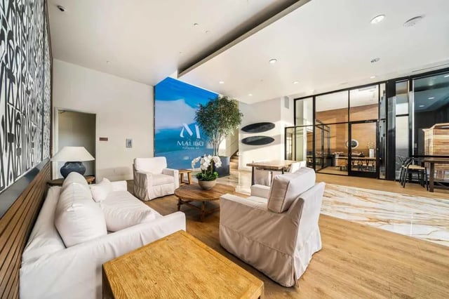 White sofas coffee tables patterned wall Malibu graphic living room at Malibu Tucson Apartments in Tucson Student Accommodation