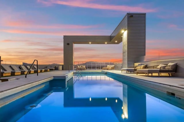 Swimming pool with lounge chairs at sunset exterior at Malibu Tucson Apartments in Tucson Student Accommodation