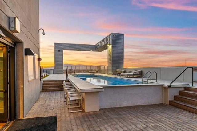 Rooftop pool with bar lounge chairs and sunset exterior at Malibu Tucson Apartments in Tucson Student Accommodation