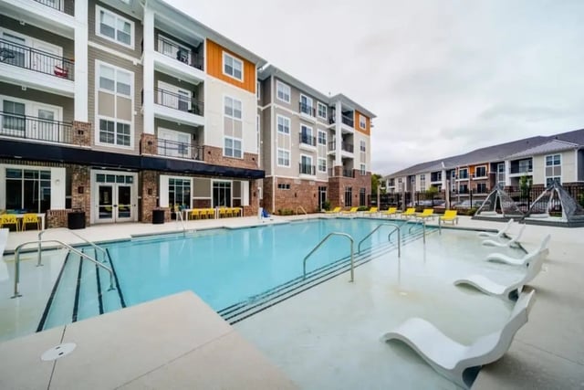 Pool lounge chairs building exterior and swimming pool. at The Eastern On 10th in Greenville Student Accommodation