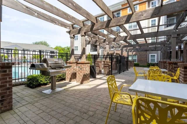 Grill tables and yellow chairs outdoor area at The Eastern On 10th in Greenville Student Accommodation