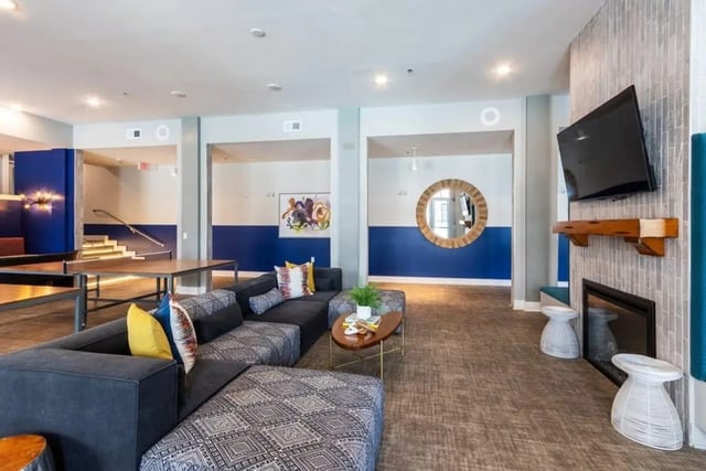 Sofa coffee table fireplace television living room at The Eastern On 10th in Greenville Student Accommodation