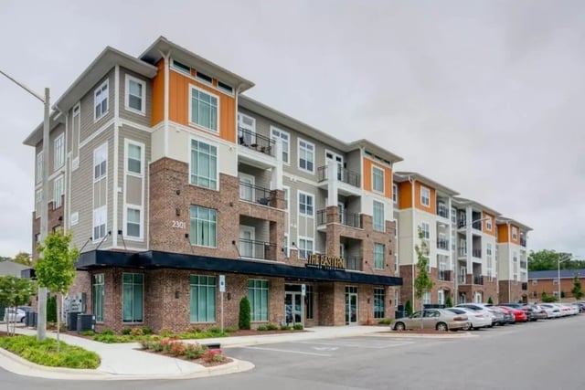Modern apartment building with balconies and parking lot exterior at The Eastern On 10th in Greenville Student Accommodation