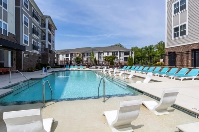 Pool with lounge chairs and buildings exterior at The Eastern On 10th in Greenville Student Accommodation