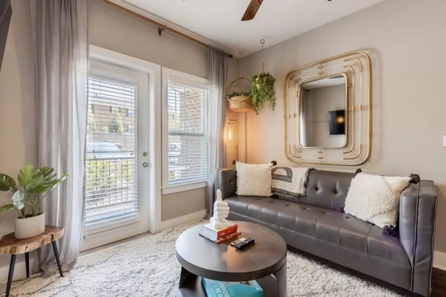 Gray tufted sofa with plush pillows living room at The Eastern On 10th in Greenville Student Accommodation