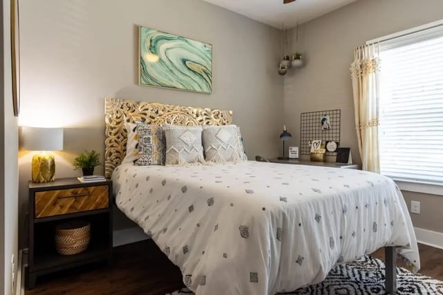 Carved headboard bed with decorative pillows and artwork bedroom at The Eastern On 10th in Greenville Student Accommodation