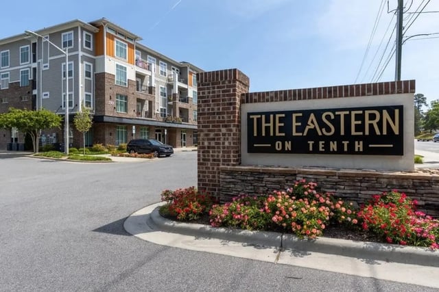 Apartment building with entrance sign and landscaping exterior at The Eastern On 10th in Greenville Student Accommodation